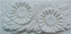 handmade ceramic tile with a high relief flower design and a one color glaze